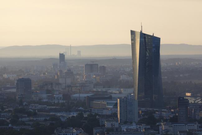 © Bloomberg. The European Central Bank (ECB) skyscraper headquarters building stands above commercial and residential property at dawn in Frankfurt, Germany, on Wednesday, July 25, 2018. The ECB president and his colleagues will set policy on Thursday, with analysts predicting the Governing Council will reaffirm that bond purchases will end in December and interest rates could start rising after the summer of 2019. 