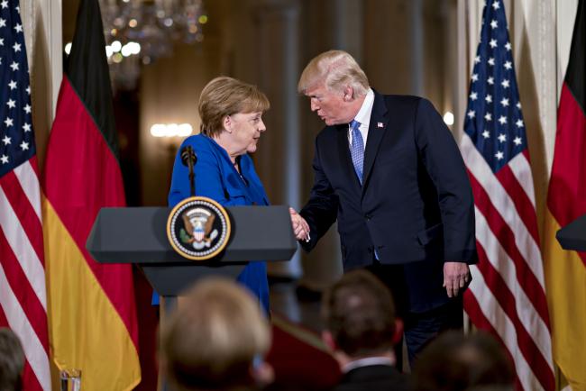 © Bloomberg. Trump shakes hands with Merkel in Washington on April 27. 