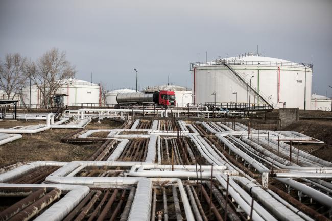 © Bloomberg. An oil transportation truck drives alongside oil storage tanks in the Duna oil refinery, operated by MOL Hungarian Oil & Gas Plc, in Szazhalombatta, Hungary, on Monday, Feb. 13, 2019. Oil traded near a three-month high as output curbs by OPEC tightened global supply while trade talks between the U.S. and China lifted financial markets. Photographer: Akos Stiller/Bloomberg