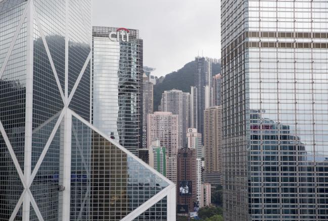 © Bloomberg. The Bank of China Tower, left, Citibank Tower, second left, and Cheung Kong Center, right, stand in the Central district of Hong Kong. Photographer: Brent Lewin