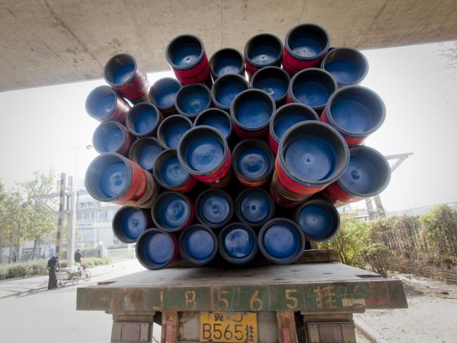 © Bloomberg. OCTG (oil country tubular goods) are loaded on a truck outside the Tianjin Pipe (Group) Corp. plant in Tianjin, China, on Tuesday, Nov. 2, 2010. 