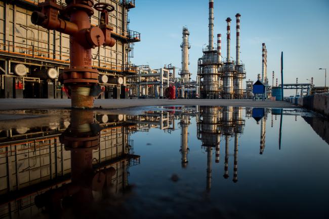 © Bloomberg. Cracking towers and chimneys sit in a reflection at the processing plant at the Persian Gulf Star Co. (PGSPC) gas condensate refinery in Bandar Abbas, Iran, on Wednesday, Jan. 9. 2019. The third phase of the refinery begins operations next week and will add 12-15 million liters a day of gasoline output capacity to the plant, Deputy Oil Minister Alireza Sadeghabadi told reporters. Photographer: Ali Mohammadi/Bloomberg
