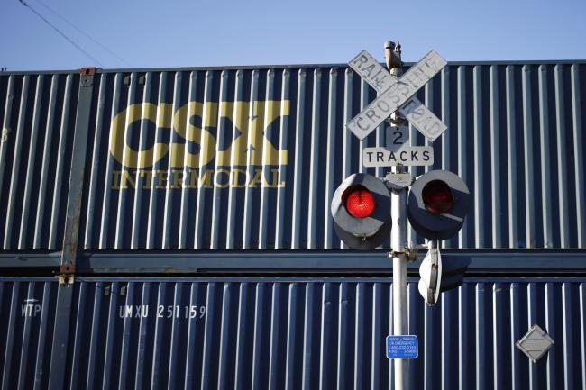 © Bloomberg. A CSX Corp. intermodal container train passes a railroad crossing sign in Louisville, Kentucky, U.S., on Friday, Oct. 13, 2017. CSX is scheduled to release earnings figures on Oct. 17. Photographer: Luke Sharrett/Bloomberg