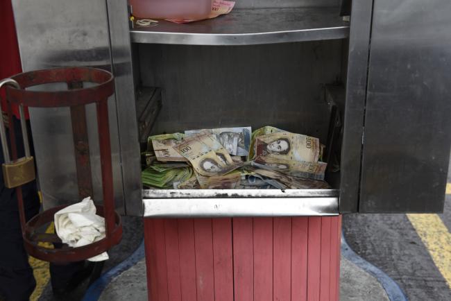 © Bloomberg. Bolivar banknotes sit in a drawer at a Petroleos de Venezuela SA (PDVSA) gas station in Caracas, Venezuela, on Saturday, Aug. 18, 2018. Venezuelan shops shuttered and lines formed at gas stations on Saturday as confusion reigned following measures announced by President Nicolas Maduro aimed at fighting an historic economic crisis in the oil-exporting nation. Photographer: Carlos Becerra/Bloomberg 