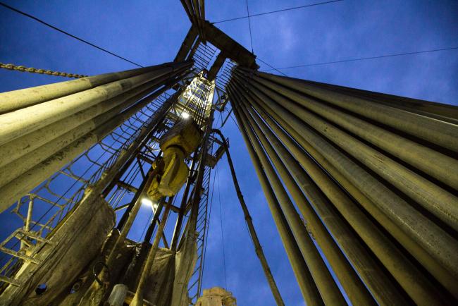 © Bloomberg. The travelling block hangs beside drill pipes on the derrick of a drill rig during oil drilling operations by Targin JSC, a unit of Sistema PJSFC, in an oilfield operated by Bashneft PAO near Ufa, Russia, on Thursday, Sept. 29, 2016. Photographer: Andrey Rudakov/Bloomberg