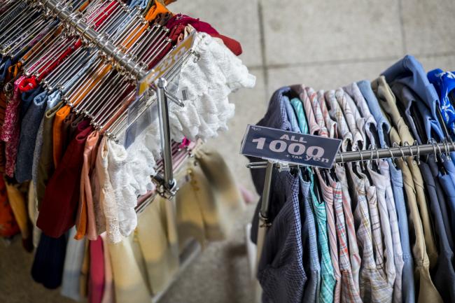 © Bloomberg. Clothes are displayed for sale on Takeshita Street in the Harajuku area of Tokyo, Japan, on Wednesday, May 23, 2018. Japan stocks led declines in most Asian equities Thusday, with the yen extending gains amid more twists and turns on trade and lingering emerging-market risks. Photographer: Shiho Fukada/Bloomberg