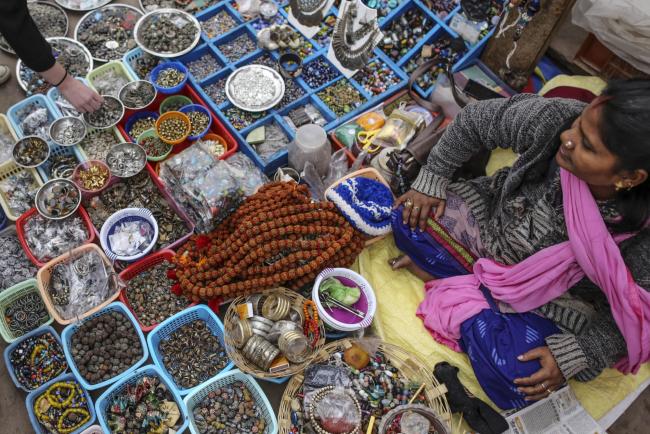 © Bloomberg. A vendor sells jewelry and accessories at Dashasumedh ghat on the banks of the Ganges river in Varanasi, Uttar Pradesh, India, on Friday, Dec. 9, 2016. India is scheduled to release Consumer Price Index (CPI) figures for November on Dec. 13. 