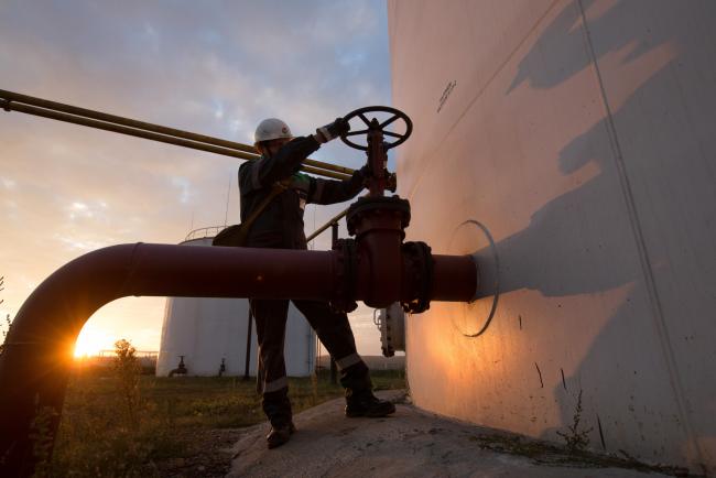 © Bloomberg. An employee turns a control valve on pipework beside a storage tank at an oil delivery point operated by Bashneft PAO in Sergeevka village, near Ufa, Russia, on Monday, Sept. 26, 2016. Bashneft distributes petroleum products and petrochemicals around the world and in Russia via filling stations. 