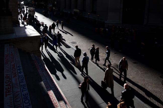 © Bloomberg. Pedestrians walk along Wall Street near the New York Stock Exchange (NYSE) in New York, U.S., on Monday, Oct. 31, 2016. U.S. stocks rose from a six-week low amid an increase in deal activity as traders assessed the outlook for the presidential election and interest rates in the world\\'s largest economy. Photographer: Michael Nagle/Bloomberg