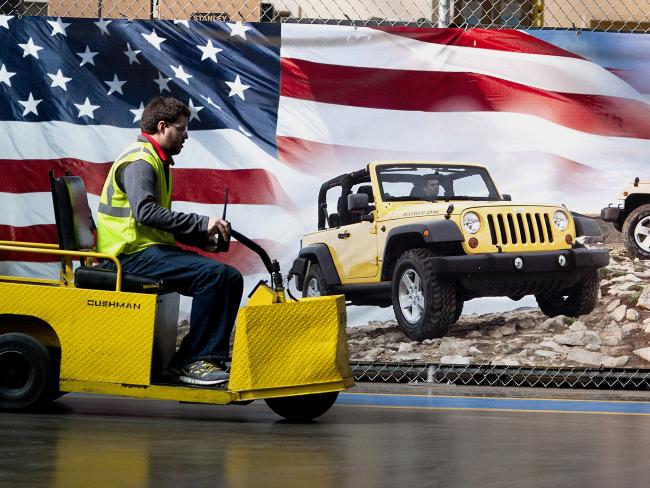© Bloomberg. An employee drives a utility cart past a Jeep banner inside the Chrysler Toledo Assembly Plant in Toledo, Ohio. Photographer: Ty Wright/Bloomberg
