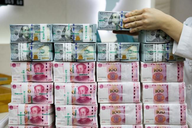 © Bloomberg. An employee arranges genuine bundles of U.S. one-hundred dollar banknotes and Chinese one-hundred yuan in an arranged photograph at the Counterfeit Notes Response Center of KEB Hana Bank in Seoul, South Korea, on Monday, Aug. 14, 2017. China's factory output and investment slowed somewhat in July, according to data released today, yet the yuan appeared not to take the data as negative, if in fact it's paying attention to it at all. Photographer: SeongJoon Cho/Bloomberg