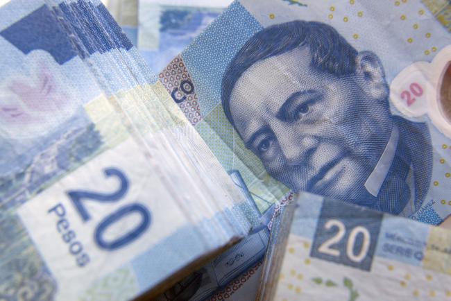 © Bloomberg. The portrait of Benito Juarez on a twenty Mexican Peso bill is seen in an arranged photograph in Mexico City, Mexico.