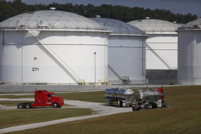 © Bloomberg. Tanker trucks sit parked at the Colonial Pipeline Co. Pelham junction and tank farm in Pelham, Alabama, U.S., on Monday, Sept. 19, 2016. Customers buying gasoline at grocery stores and other independent retailers may pay more than those shopping at name-brand outlets after the biggest gasoline pipeline in the U.S. sprung a leak in Alabama on Sept. 9. Colonial Pipeline Co. has proposed restarting the line on Sept. 22, according to the Alabama Emergency Management Agency.
