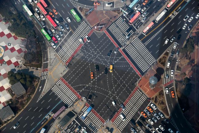 © Bloomberg. Traffic moving through an intersection is seen from the observation deck of the Lotte Corp. World Tower in Seoul. 