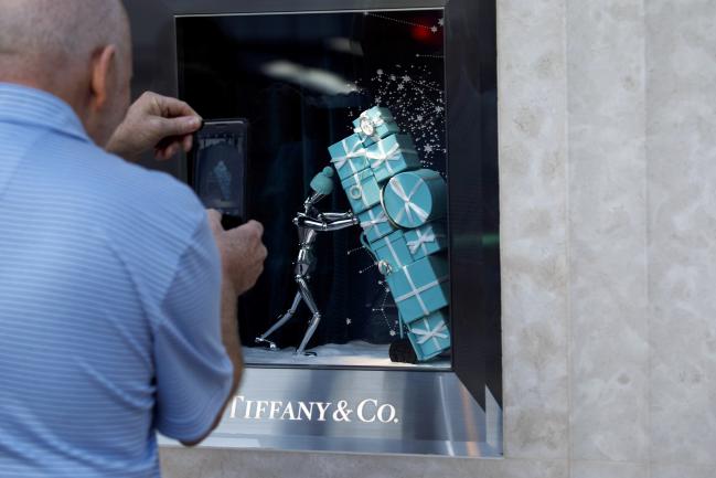 © Bloomberg. A pedestrian uses a mobile device to take a photograph of a holiday window display at the Tiffany & Co. store on Rodeo Drive in Beverly Hills, California, U.S., on Sunday, Nov. 26, 2017. Tiffany & Co. is scheduled to release earnings figures on November 29. Photographer: Patrick T. Fallon/Bloomberg