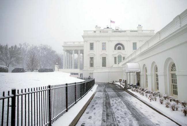 © Bloomberg. An American flag flies outside the White House during a snow storm in Washington, D.C., U.S., on Wednesday, March 21, 2018. Photographer: Eric Thayer/Bloomberg