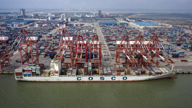 © Bloomberg. A China Ocean Shipping Group Co. (COSCO) container ship sits moored next to gantry cranes at the Port of Nansha, operated by Guangzhou Port Group Co., in this aerial photograph taken in the Nansha district of Guangzhou, China, on Thursday, April 11, 2019. The U.S. is open to facing 