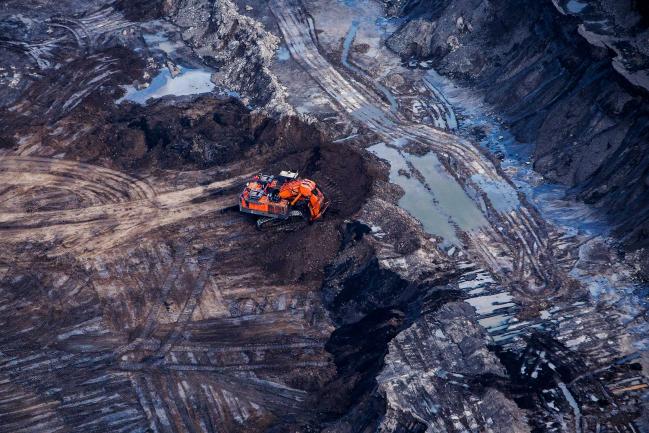 © Bloomberg. An excavator is seen at the Suncor Energy Inc. Millennium mine in this aerial photograph taken above the Athabasca oil sands near Fort McMurray, Alberta, Canada, on Monday, Sept. 10, 2018. Photographer: Ben Nelms/Bloomberg