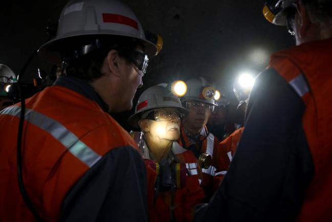 © Bloomberg. Nelson Pizarro, chief executive officer of Coldeco Metals Inc., center, speaks with employees inside the company's Teniente copper mine near Rancagua, Chile, on Wednesday, March 21, 2018. Mining veteran Pizarro has spent more than half a century working in mines and has dedicated the last four years to turning the world's largest copper producer into a profitable company. Photographer: Laura Millan Lombrana/Bloomberg