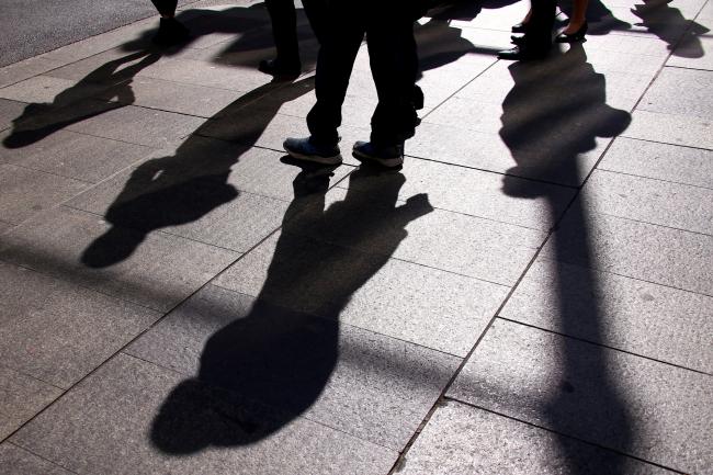 © Bloomberg. Pedestrians cast shadows on the ground as they walk in the central business district of Sydney, Australia, on Wednesday, May 15, 2019. Australia's economy has been weighed down by a retrenchment in household spending as property prices slump and slash personal wealth. An election Saturday is likely to see the opposition Labor party win power and lift spending further. Photographer: David Gray/Bloomberg