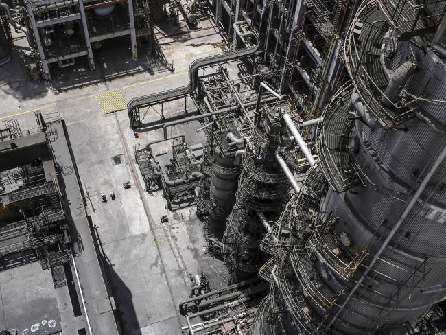 © Bloomberg. Employees walk through a refinery complex near Vadinar, Gujarat, India. Photographer: Dhiraj Singh/Bloomberg