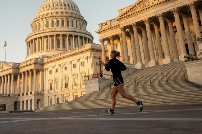 © Bloomberg. A jogger runs past the United States Capitol building at sunrise in Washington, D.C., U.S.