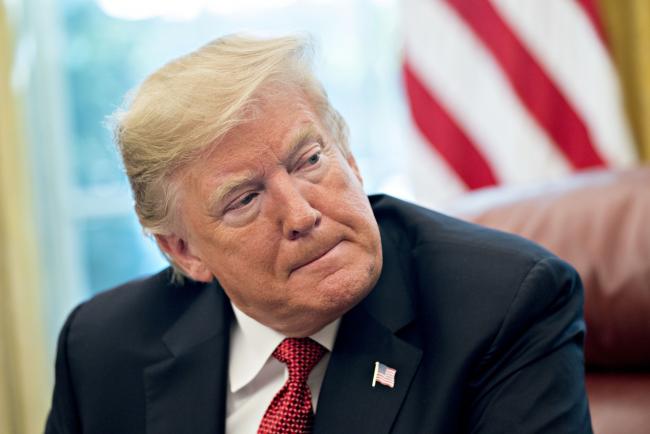 © Bloomberg. U.S. President Donald Trump listens while meeting with workers in the Oval Office of the White House during a 