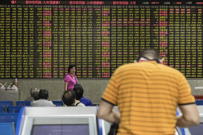 © Bloomberg. An investor stands at a trading terminal in front of an electronic stock board at a securities brokerage in Shanghai, China, on Wednesday, May 30, 2018. Foreign investors are about to get a bargain. At least, that's the optimistic slant after Chinese equities slumped for the longest stretch since 2013, taking valuations back to two-year lows right before they feature on MSCI Inc. indexes from June 1. Photographer: Qilai Shen/Bloomberg