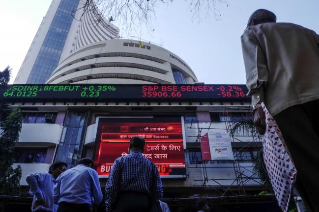 © Bloomberg. Pedestrians look up at an electronic ticker board showing a budget news report outside the Bombay Stock Exchange (BSE) in Mumbai, India, on Thursday, Feb. 1, 2018. Prime Minister Narendra Modi's government ended a tax break on equity investments as it taps the stock market boom to boost its coffers. Photographer: Dhiraj Singh/Bloomberg