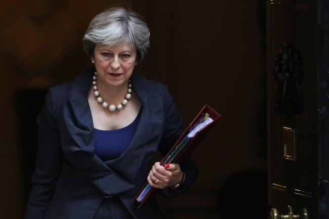 © Bloomberg. Theresa May, U.K. prime minister, carries a document folder as she leaves number 10 Downing Street on her way to attend the weekly questions and answers session in Parliament in London, U.K., on Wednesday, Oct. 11, 2017. May and her most senior cabinet ministers risk igniting the anger of their Tory colleagues with a series of comments that raise questions over their commitment to Brexit.