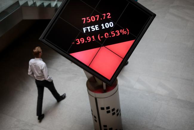 © Bloomberg. Employees walk past FTSE 100 share price information displayed on an illuminated rotating cube in the atrium of the London Stock Exchange Group Plc's offices in London, U.K., on Tuesday, May 30, 2017. The FTSE 100 Index has climbed 4.8 percent this month, one of the best gains among developed-market equities and a much bigger advance than its largest European peers. Photographer: Simon Dawson/Bloomberg