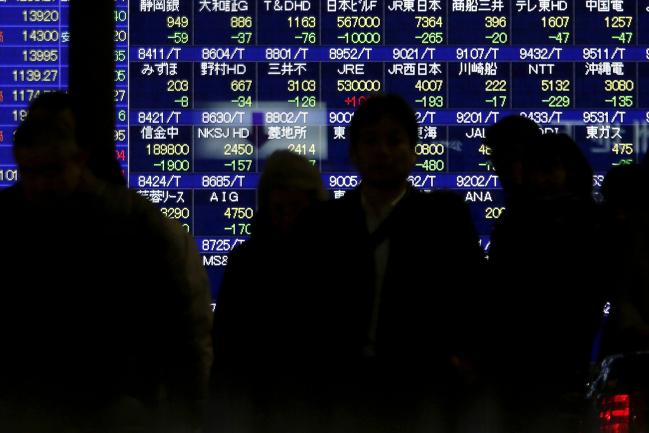 © Bloomberg. Pedestrians walk in front of an electronic stock board outside a securities firm in Tokyo, Japan, on Tuesday, Feb. 4, 2014. Japanis Topix index headed for its biggest drop in eight months after the yen surged against the dollar as investors shunned risk assets amid concern about the global economic outlook.