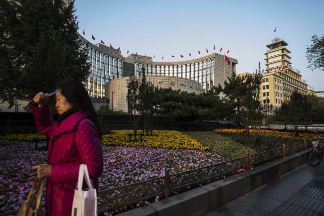 © Bloomberg. A pedestrian walks past the People's Bank of China headquarters in Beijing, China, on Monday, Oct. 23, 2017. China's central bank is said to have gauged demand for 63-day reverse repurchase agreements for the first time ever. 