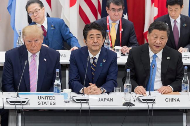 © Bloomberg. US President Donald Trump (L) sits with Japan's Prime Minister Shinzo Abe (C) and China's President Xi Jinping as they attend a meeting on the digital economy at the G20 Summit in Osaka on June 28, 2019.  