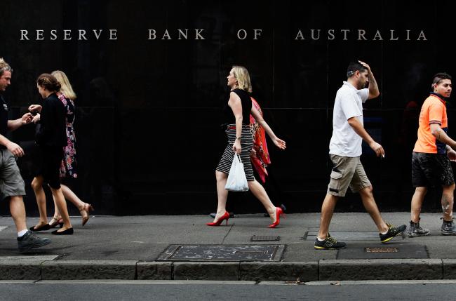 © Bloomberg. Pedestrians walks past the Reserve Bank of Australia (RBA) headquarters in the central business district of Sydney, Australia. Photograph: Lisa Maree Williams/er:Bloomberg Photographer: Lisa Maree Williams/ 