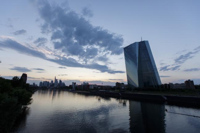 © Bloomberg. The European Central Bank (ECB) skyscraper headquarters stand beside the River Main at dusk in Frankfurt, Germany, on Tuesday, July 17, 2018. Frankfurt's efforts to attract bankers escaping Brexit are in danger of losing momentum. 