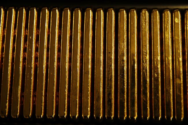 © Bloomberg. One kilogram bars of gold sit stacked in a row at the Valcambi SA precious metal refinery in Balerna, Switzerland, on Tuesday, April 24, 2018. Gold's haven qualities have come back in focus this year as President Donald Trump’s administration picks a series of trade fights with friends and foes, and investors fret about equity market wobbles that started on Wall Street and echoed around the world. Photographer: Stefan Wermuth/Bloomberg