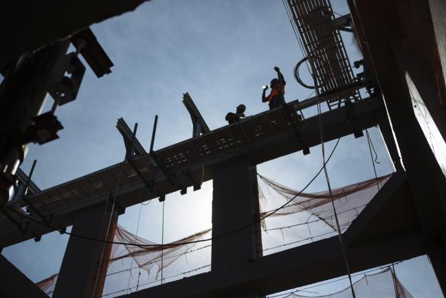 © Bloomberg. Workers install fittings for the facade of a luxury condominium building under construction at 277 5th Avenue, a Lendlease Corp. joint venture with Victor Group, in New York, U.S., on Friday, June 29, 2018. The U.S. Census Bureau is scheduled to release construction spending figures on July 2. Photographer: Angus Mordant/Bloomberg