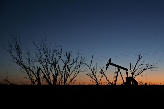 © Bloomberg. The silhouette of a pumpjack is seen at dusk in the Permian Basin near Midland, Texas, U.S. Photographer: Daniel Acker/Bloomberg