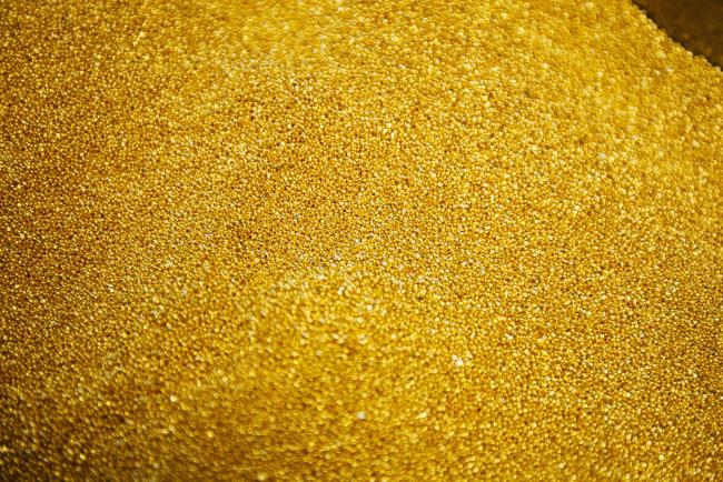 © Bloomberg. Gold bullion granules sit in a container at a refinery in Germiston, South Africa.