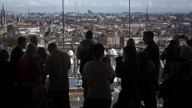 © Bloomberg. Visitors look out over the Dublin city skyline from the viewing gallery in the Guinness Gravity Bar at the company's St. James's Gate Brewery, in Dublin, Ireland, on Saturday, March 16, 2013. Irelandâs renewed competiveness makes it a beacon for the U.S. companies such as EBay, Google Inc. and Facebook Inc., which have expanded their operations in the country over the past two years. 