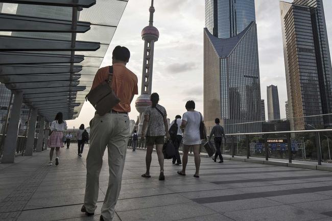 © Bloomberg. Pedestrians walk along an elevated walkway in the Lujiazui Financial District in Shanghai, China, on Monday, Sept. 4, 2017. The Chinese central bank\\'s tight leash on liquidity is straining the bond market, with the benchmark sovereign yield climbing to near the highest level since April 2015.