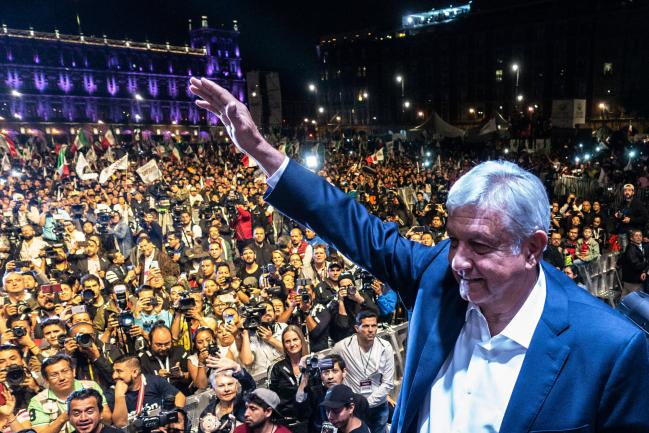 © Bloomberg. Andres Manuel Lopez Obrador, winner of Mexico's presidential election, right, waves during a rally at Zocalo square in Mexico City, Mexico, on Sunday, July 1, 2018. Photographer: Cesar Rodriguez/Bloomberg