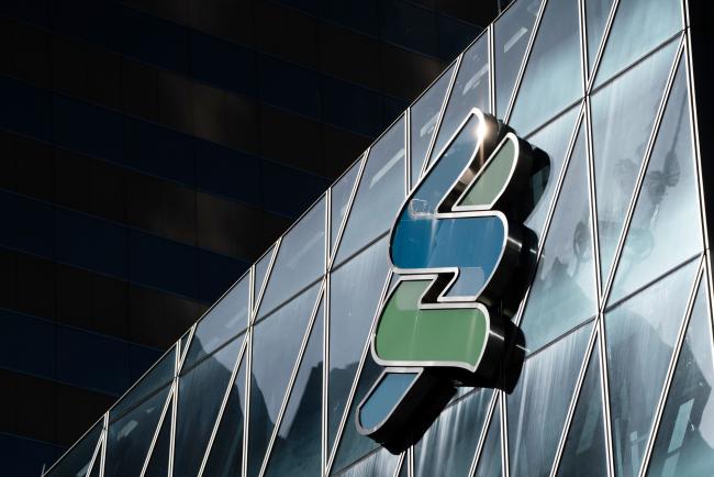 © Bloomberg. The Standard Chartered Plc logo is displayed atop the Standard Chartered Wealth Management Centre in Hong Kong, China, on Tuesday, July 31, 2018. Standard Chartered, one of the biggest financiers of global trade, isn’t losing sleep over an increasingly fractious relationship between the world’s two largest economies. Photographer: Anthony Kwan/Bloomberg