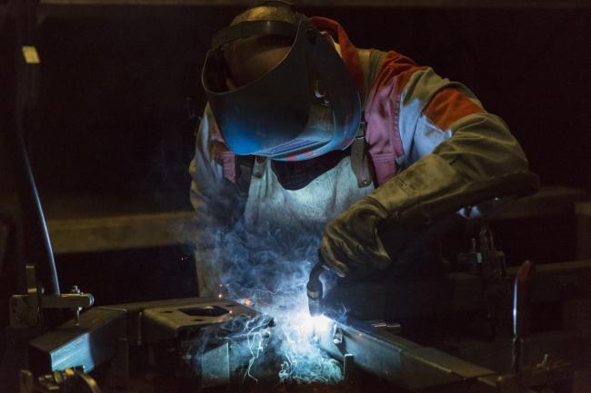 © Bloomberg. An employee welds the frame of a driver's cabin for a Pistenbully 400 snow groomer on the production line at the Pistenbully factory, a unit of Kassbohrer Gelandefahrzeug AG, in Laupheim, Germany.