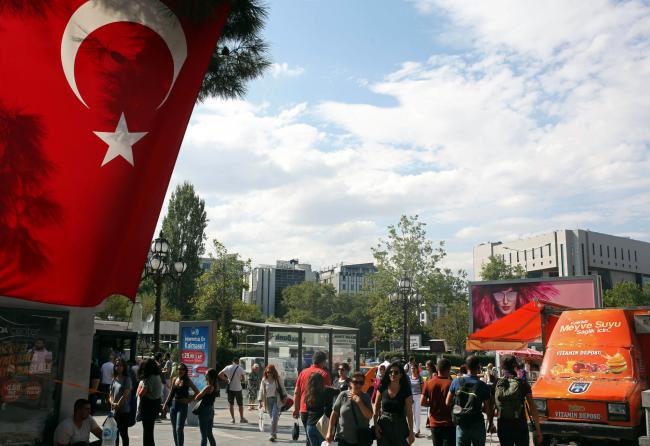 © Bloomberg. A Turkish national flag hangs above retail kiosks on a street in Ankara, Turkey 