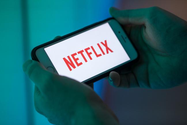 © Bloomberg. The logo for Netflix Inc. sits on an Apple Inc. iPhone smartphone in this arranged photograph in London, U.K., on Monday, Aug. 20, 2018. The NYSE FANG+ Index is an equal-dollar weighted index designed to represent a segment of the technology and consumer discretionary sectors consisting of highly-traded growth stocks of technology and tech-enabled companies. Photographer: Jason Alden/Bloomberg