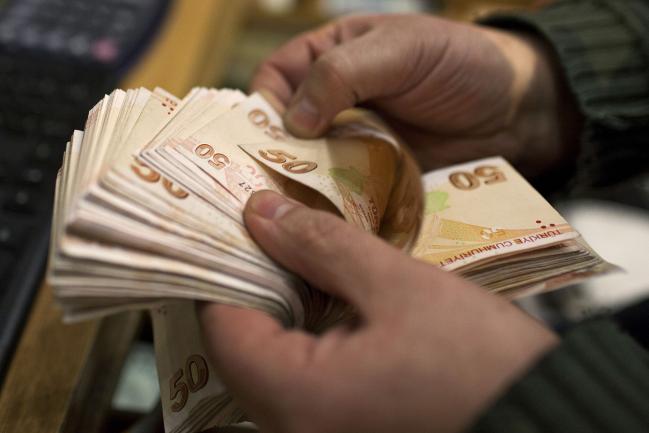 © Bloomberg. An employee counts out 50 Turkish lira banknotes at a currency exchange office in Istanbul, Turkey, on Monday, Jan. 27. 2014. The lira appreciated the most this month while stocks and bonds erased declines on speculation the central bank will raise interest rates at a surprise policy meeting tomorrow.