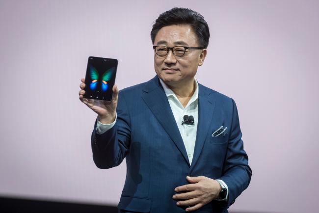 © Bloomberg. DJ Koh, president of mobile communications at Samsung, holds a Galaxy Fold during the Samsung Unpacked event on Feb. 20. Photographer: David Paul Morris/Bloomberg