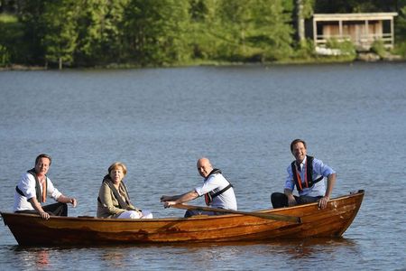 British PM Cameron, German Chancellor Merkel, Swedish PM Reinfeldt and Dutch PM Rutte sit in a punt with Reinfeldt handling the oars in a lake at Harpsund, southwest of Stockholm